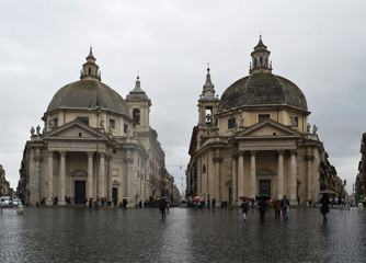 Fototapeta na wymiar Two medieval churches in Piazza Popolo in Rome in the rain.