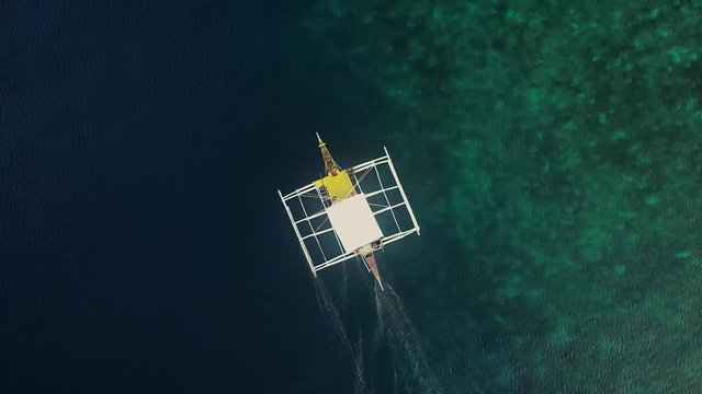 Aerial view of traditional filipino fishing boat sailing near Lapu-Lapu city, Philippines.