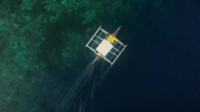 Aerial view of traditional filipino fishing boat sailing near Lapu-Lapu city, Philippines.