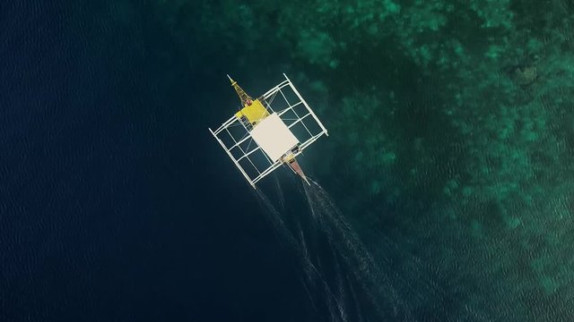Aerial view of traditional filipino fishing boat sailing near Lapu-Lapu city, Philippines.