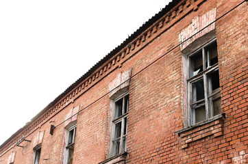 Fototapeta na wymiar Orange brick wall of old abandoned house with broken windows background.
