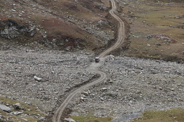 View of track passing through the rocks under cloudy sky