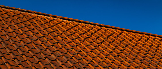 Rotes Ziegeldach mit blauem Himmel