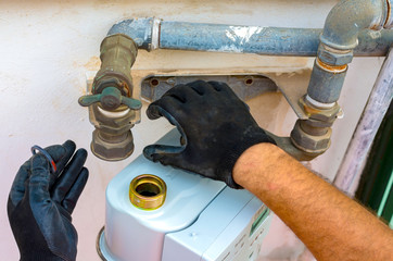 Worker insert the seals to the fitting between the pipe and gas meter. Selective focus