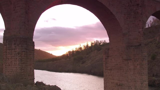 Cinematic track and tilt up to an archway of Alc&radic;&deg;ntara Bridge