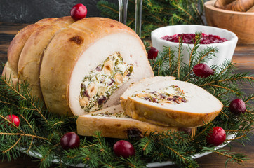Baked turkey breast roll stuffed with feta cheese, hazelnuts, cranberries and parsley, Christmas...