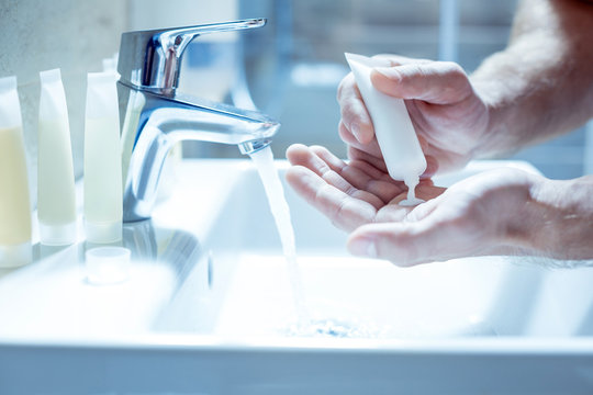 Mature Man Purring Some Soap On His Hands While Washing Face