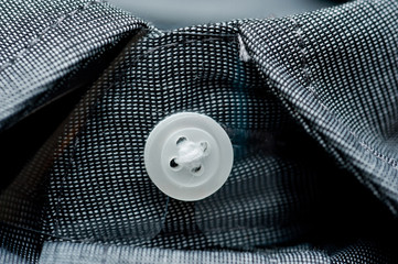 Texture of dark gray shirt fabric with white buttons close-up shot