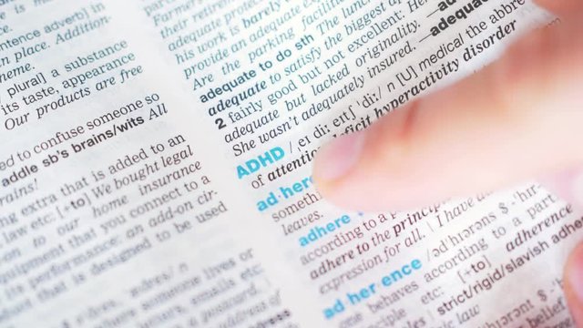 searching for and finding a word ADHD definition in a dictionary