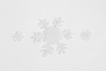 White felt snowflakes on a white background.