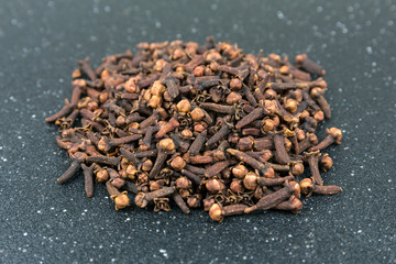 Whole clove heads and pieces isolated over black