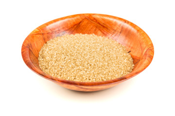 Scoop of raw cane sugar isolated over white