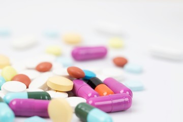 close up macro Pill spilling out disrupted. colorful pills capsule on to surface tablets on a white background. drug medical healthcare concept.