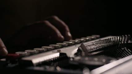 Extreme close up of hands typing on an old dusty vintage typewriter in slow motion