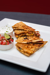 Spanish or Mexican dish Quesadilla served with salad and sauce