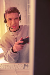 Upset handsome teenager boy passionately playing games