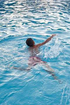 Kid swims in a pool.