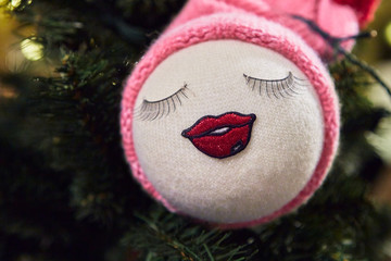 Christmas wool knitted round ball toy with pink cap on a Christmas tree.