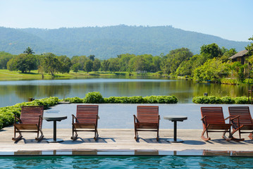 Landscape view of swimming pool and chairs with mountain view and nature