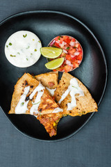 Spanish or Mexican dish Quesadilla served with salad and sauce