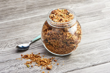 Homemade granola in a glass jar on a wooden table