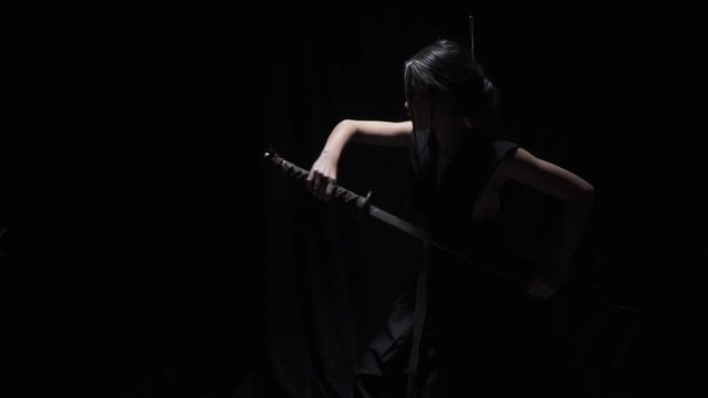 Japanese warrior woman in fighting stance, training, pulling out the katana