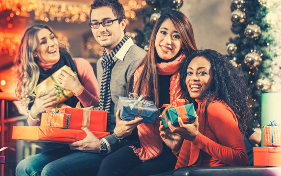 Diversity Friends with Christmas presents and bags shopping in mall with light decoration