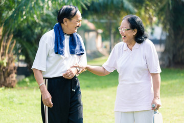 Senior woman holding the hand of her husband standing in the park