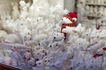 All white christmas gifts souvenirs and toys on the advent market stall: bears, rabbits, snowmen,