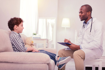 Obraz premium Positive friendly doctor speaking with his patient