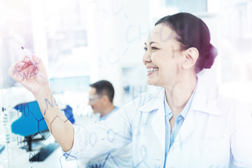 Positive pleasant smart woman studying chemical formula