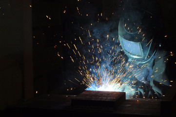 factory welder welds metal structures for construction purposes