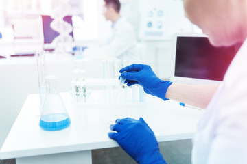 Fototapeta premium Professional female scientist wearing blue rubber gloves