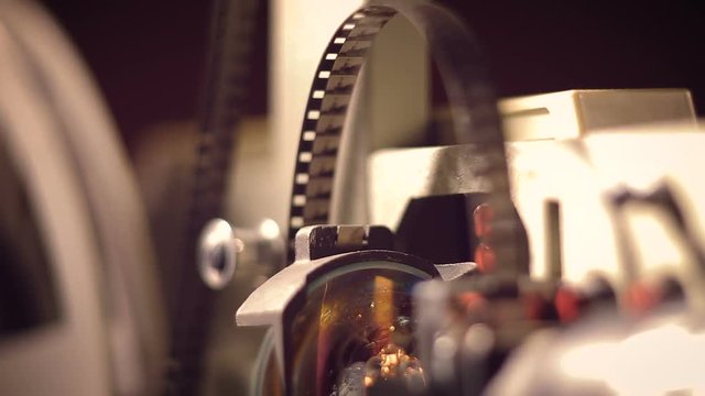 film projector on a black background with dramatic lighting and selective focus.
