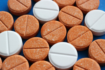 Orange and white tablets of glucose and vitamin c.