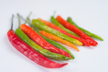 Close-up of colorful hot peppers. Group of red green and yellow peppers on white background