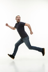 Man running fast at white studio background