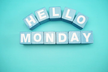 hello monday with blue wooden cubes alphabet letter on blue background