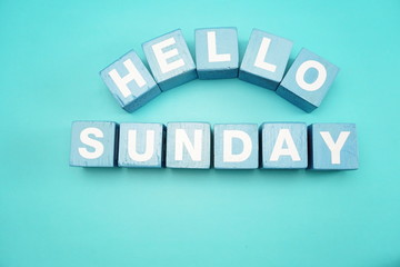 hello sunday with blue wooden cubes alphabet letter on blue background