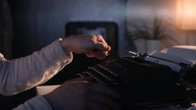 Man's hands type on an old vintage typewriter