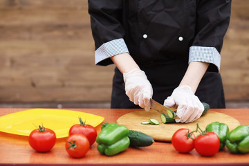 The cook cuts fresh farm vegetables