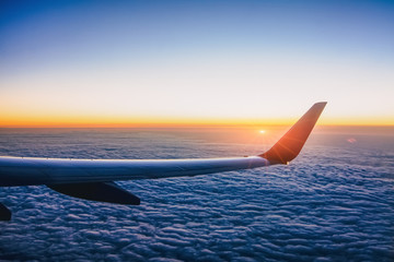 Airplane wing with sunset in light flare