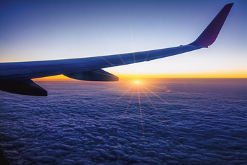 Airplane wing with sunset in light flare
