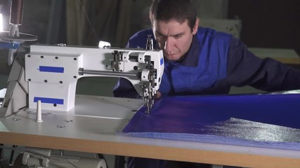 portrait of a man at a sewing machine at work