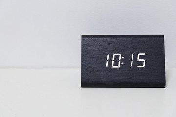 Black digital clock on a white background showing time 10:15