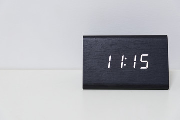 Black digital clock on a white background showing time 11:15