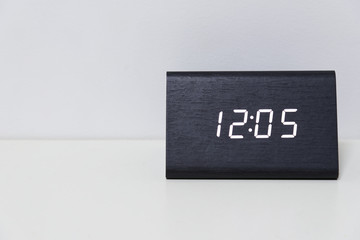 Black digital clock on a white background showing time 12:05