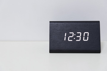 Black digital clock on a white background showing time 12:30