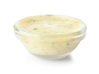 Tasty yellow sauce in glass bowl on white background