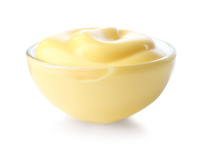 Tasty yellow sauce in glass bowl on white background